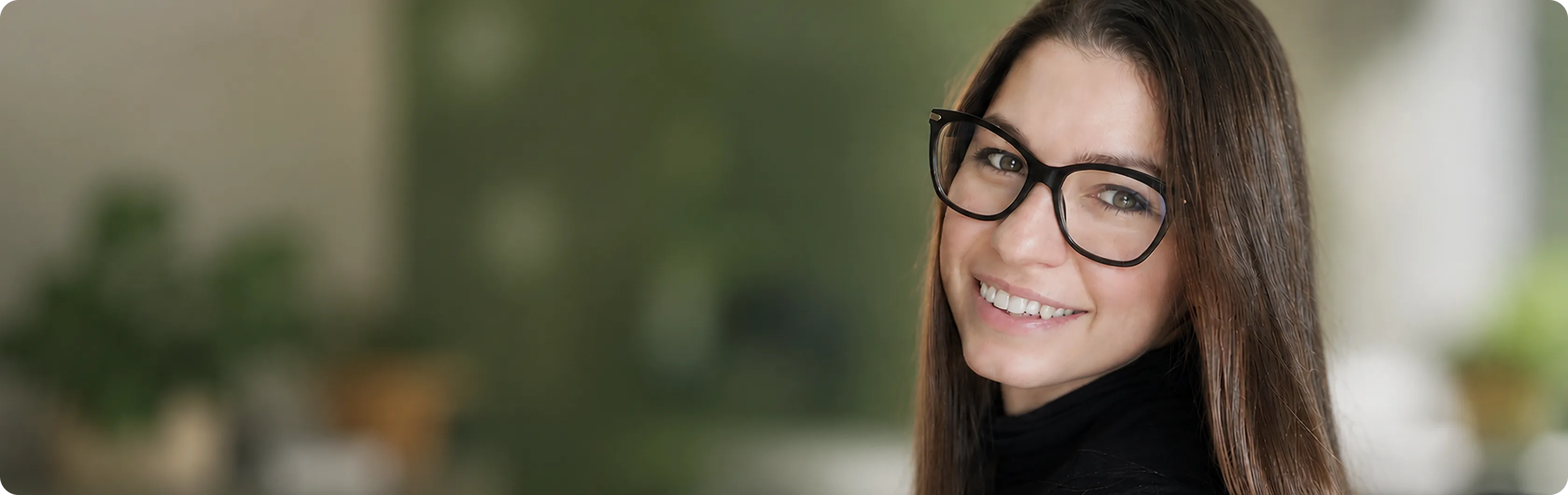 Portrait of a smiling yoga studio manager wearing glasses.